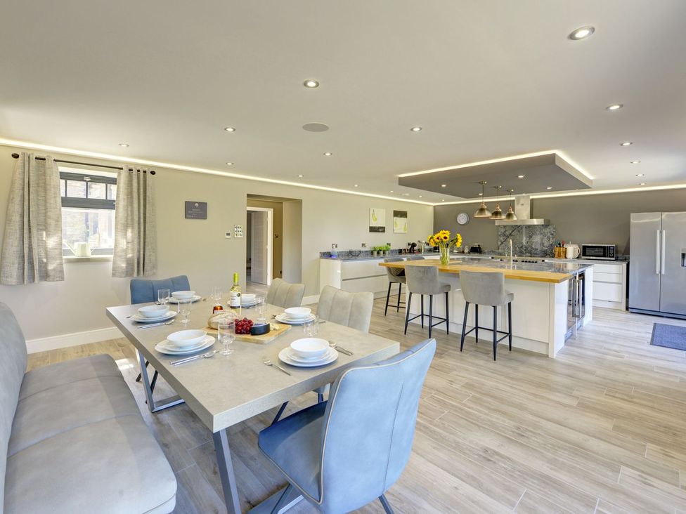 A kitchen with a dining table and kitchen island at The Gate House in Aldbrough St. John near Barton