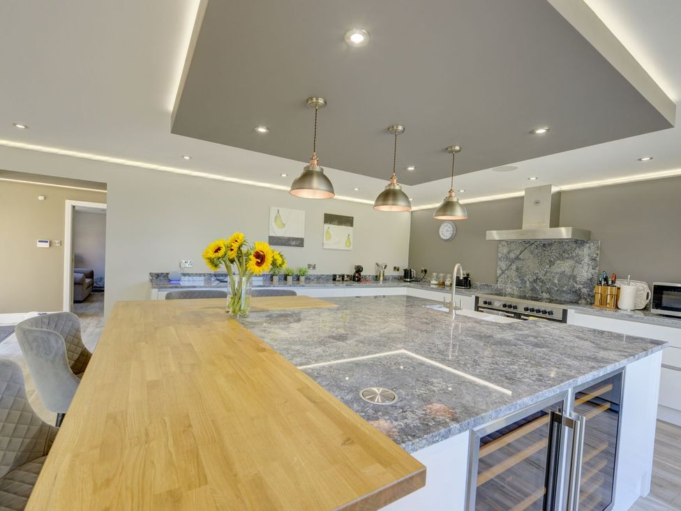 A kitchen with an island and flowers at The Gate House in Aldbrough St. John near Barton