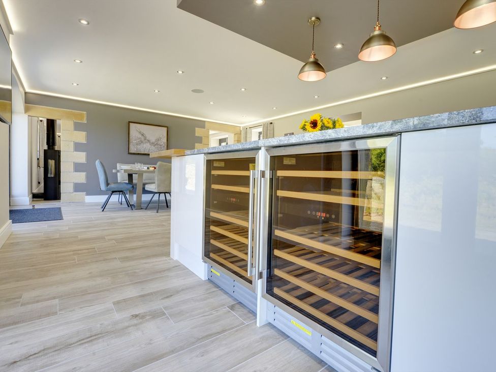 A kitchen with a wine cooler and table at The Gate House in Aldbrough St. John near Barton
