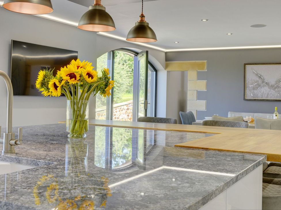 A kitchen with a sink and flowers on the counter at The Gate House in Aldbrough St. John near Barton