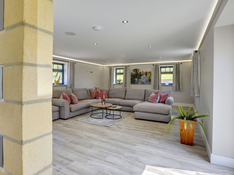 A living room with a large sofa and coffee table at The Gate House in Aldbrough St. John near Barton