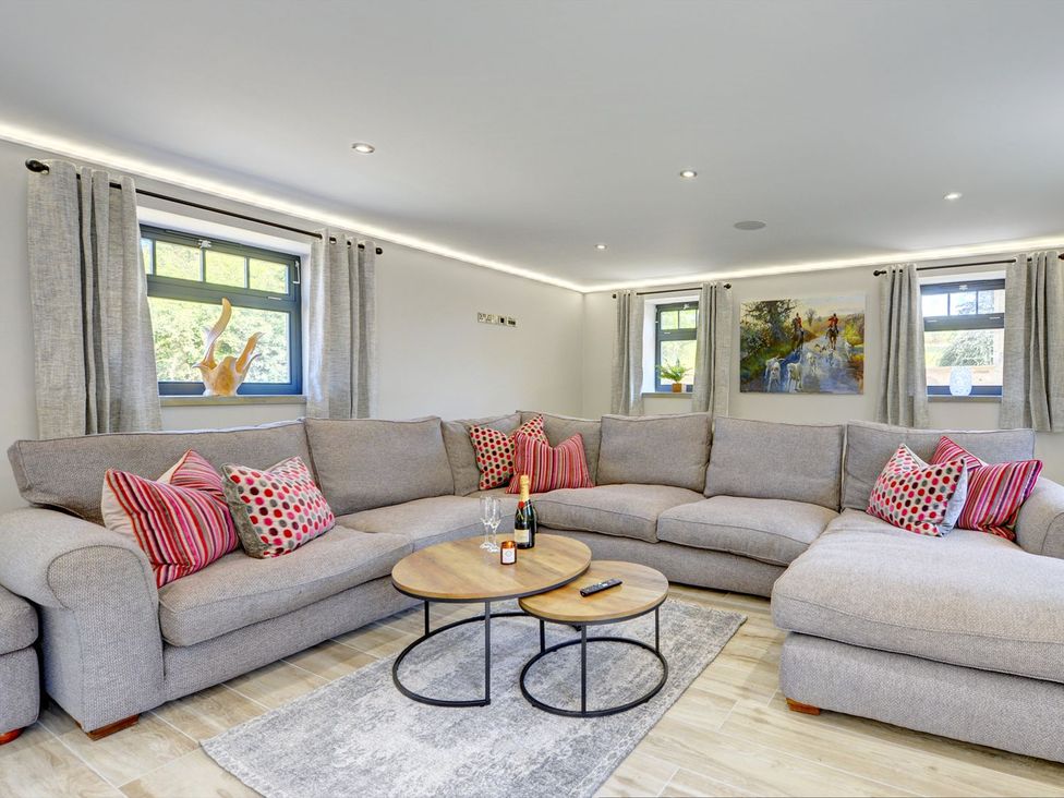 A living room with a sofa, coffee table, and curtains at The Gate House in Aldbrough St. John near Barton