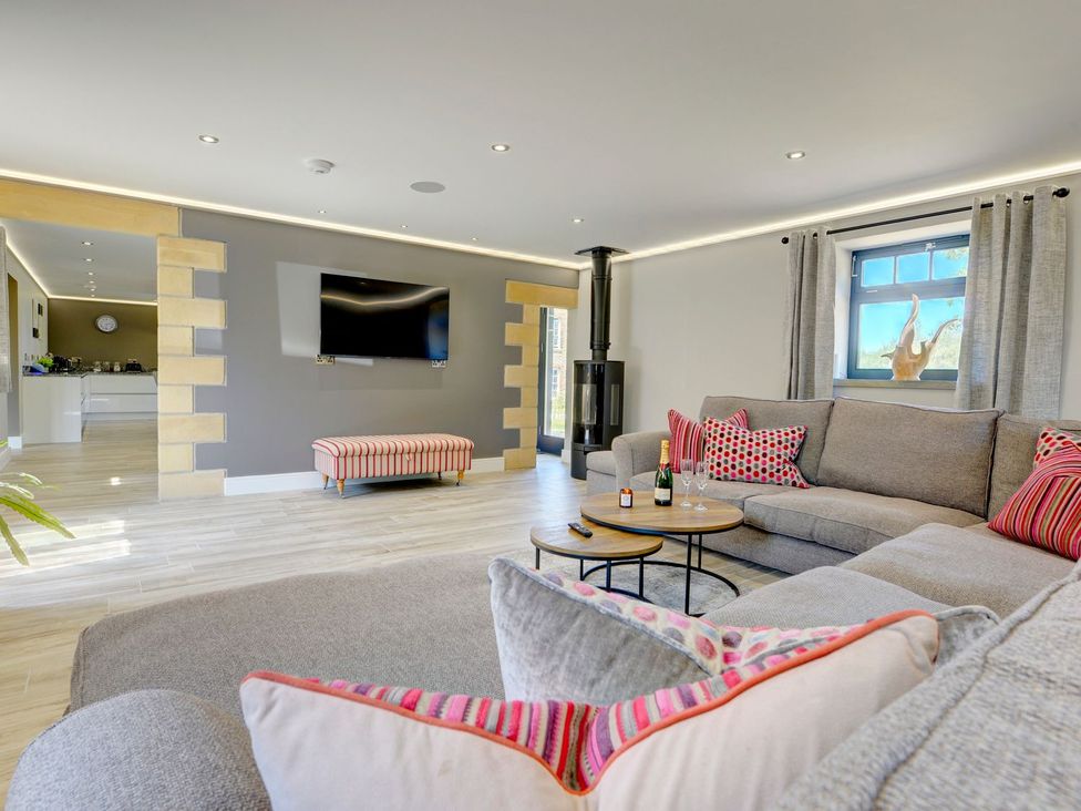 A living room with a sofa, coffee table and television at The Gate House in Aldbrough St. John near Barton