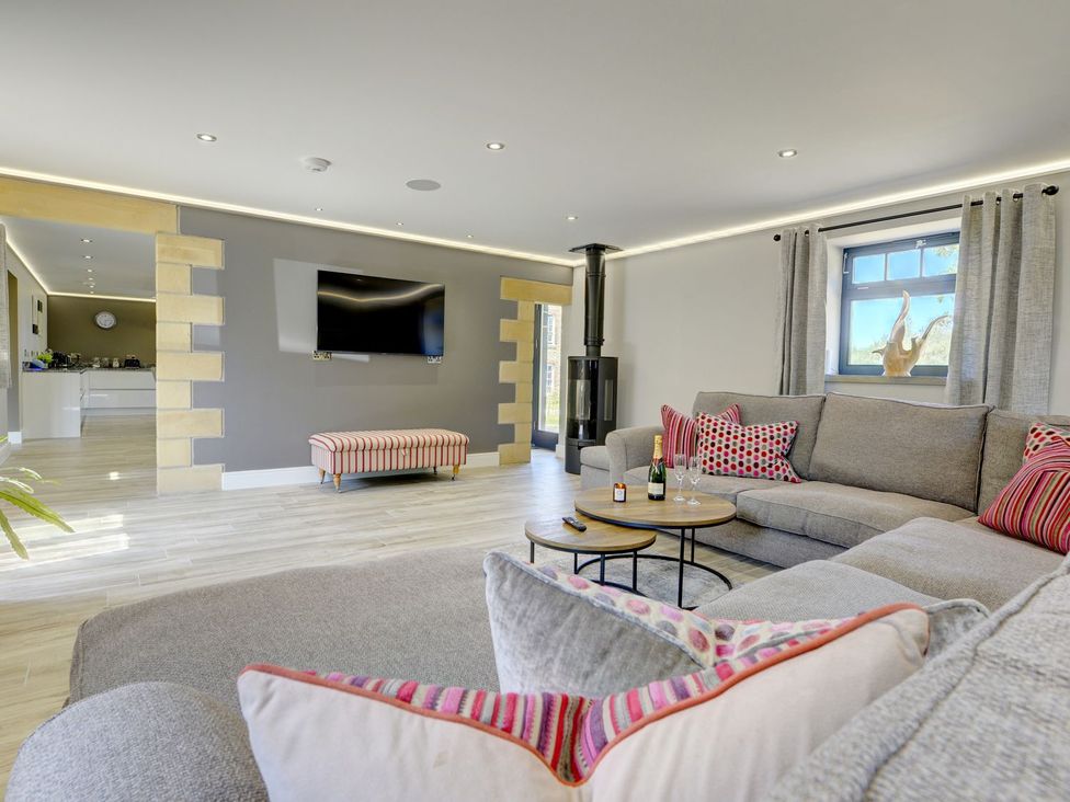 A living room with a sofa and TV at The Gate House in Aldbrough St. John near Barton