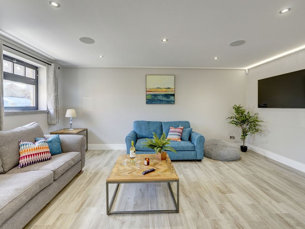 A living room with a blue sofa and coffee table at The Gate House in Aldbrough St. John near Barton