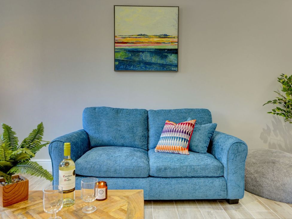 A living room with a blue sofa and a coffee table at The Gate House Aldbrough St. John near Barton