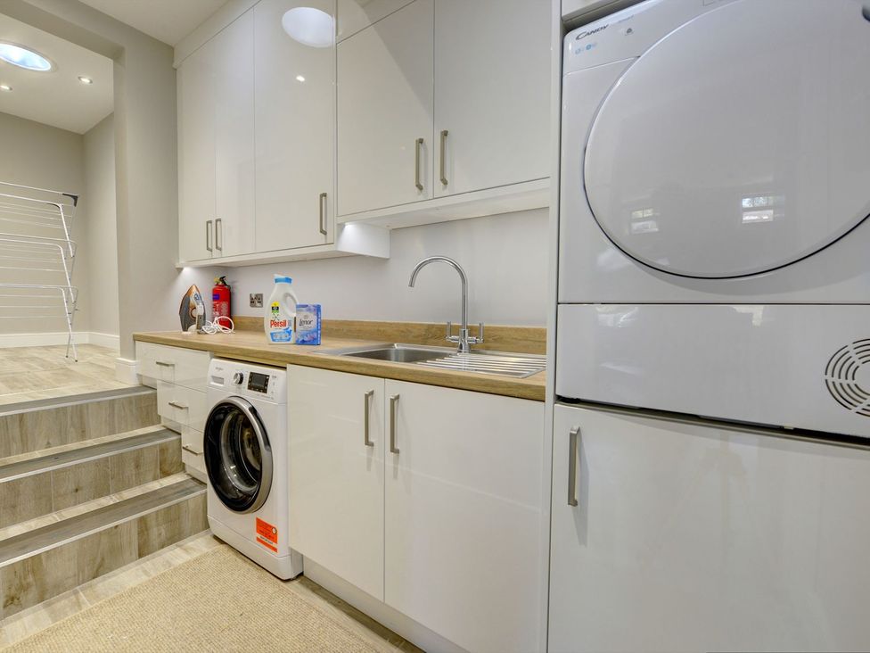 A laundry room with a washing machine and tumble dryer at The Gate House in Aldbrough St. John near Barton