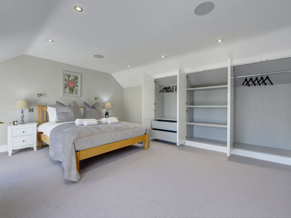 A bedroom with a bed and wardrobe at The Gate House in Aldbrough St. John near Barton