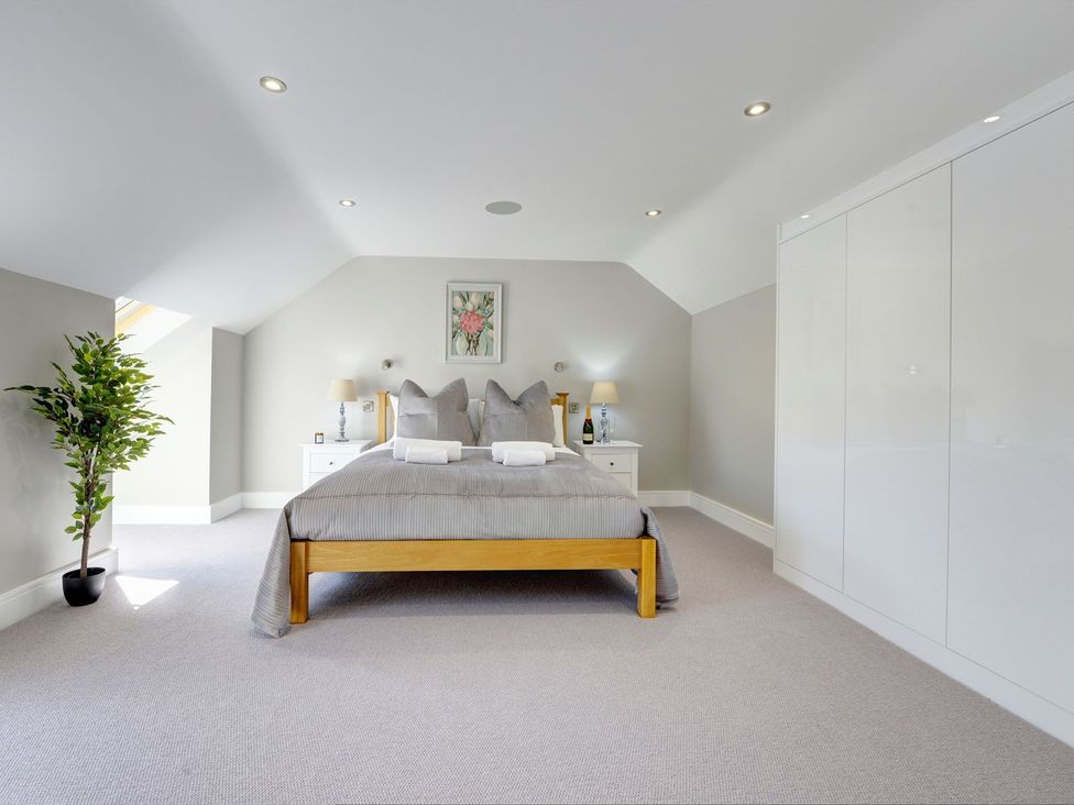 A bedroom with a bed and nightstands at The Gate House near Aldbrough St. John