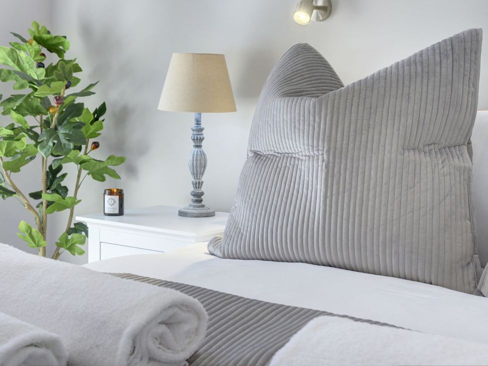 A bedroom with a large pillow and lamp at The Gate House in Aldbrough St. John near Barton