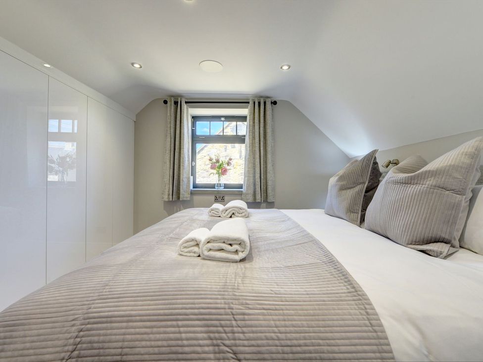 A bedroom with a bed and a window at The Gate House near Aldbrough St. John