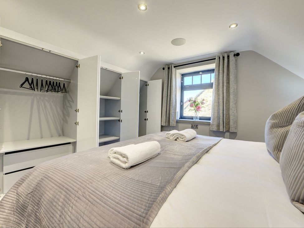 A bedroom with a bed and wardrobe at The Gate House in Aldbrough St. John near Barton