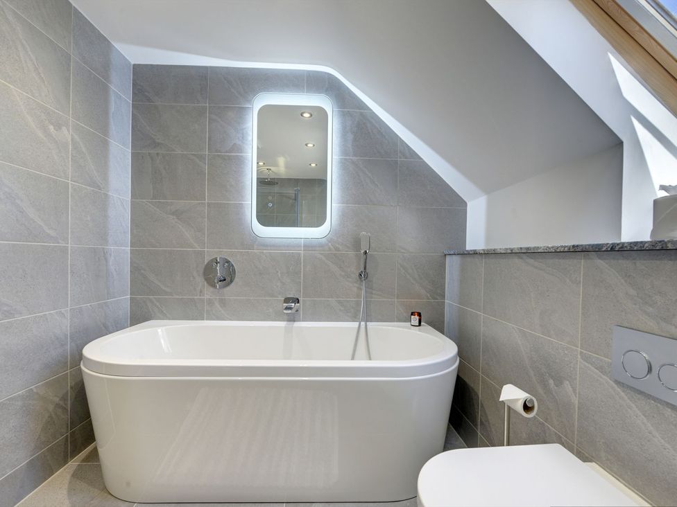 A bathroom with a bathtub and toilet at The Gate House in Aldbrough St. John near Barton