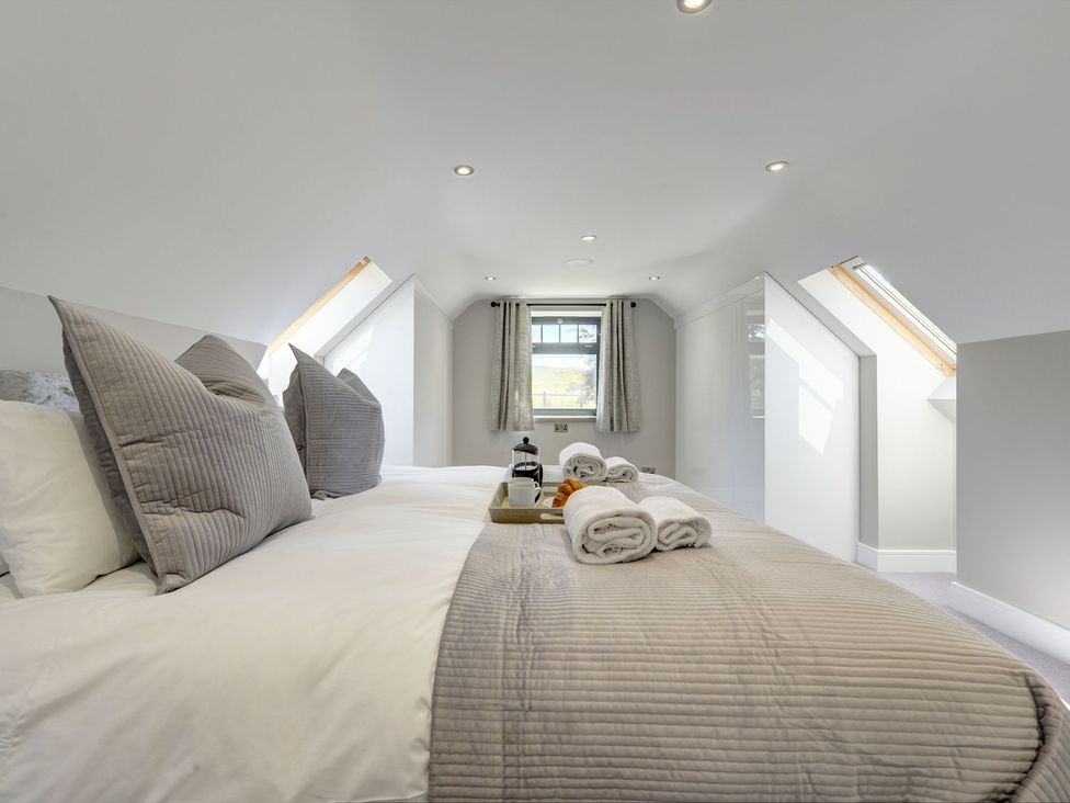 A bedroom with a bed and towels on a tray at The Gate House in Aldbrough St. John near Barton