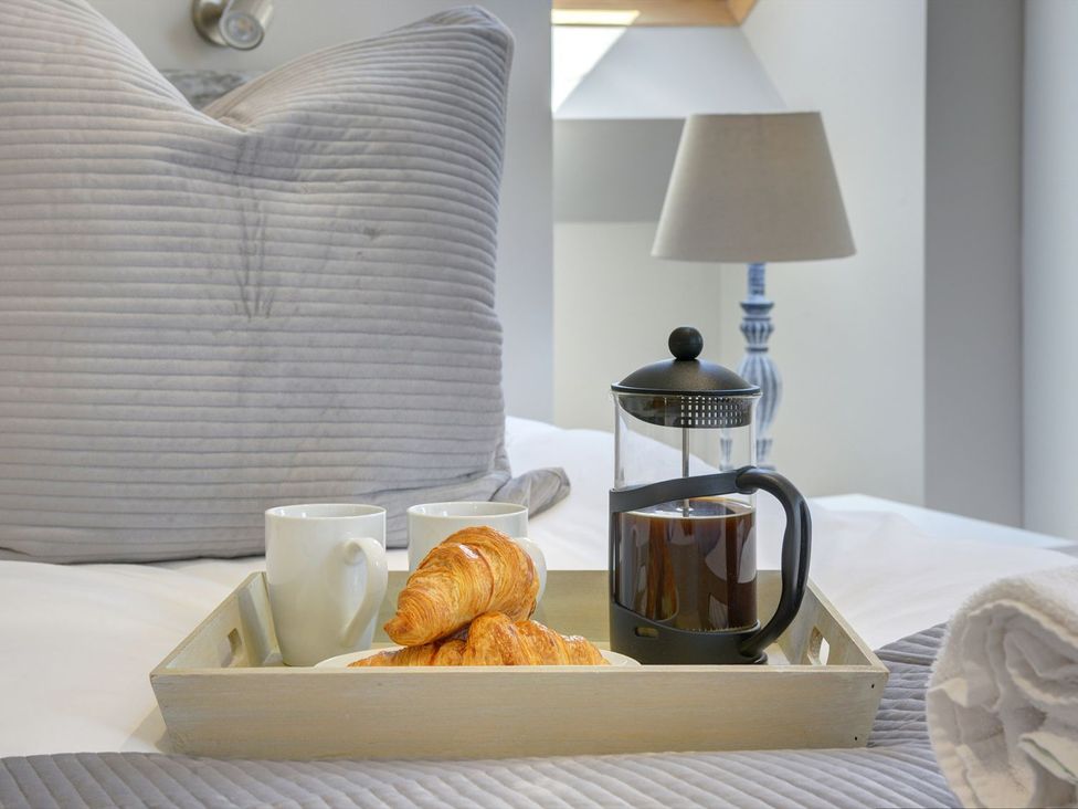 A breakfast tray with coffee and croissants in a bedroom at The Gate House in Aldbrough St. John near Barton