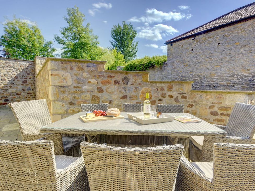 An outdoor dining area with a table and chairs at The Gate House near Aldbrough St. John
