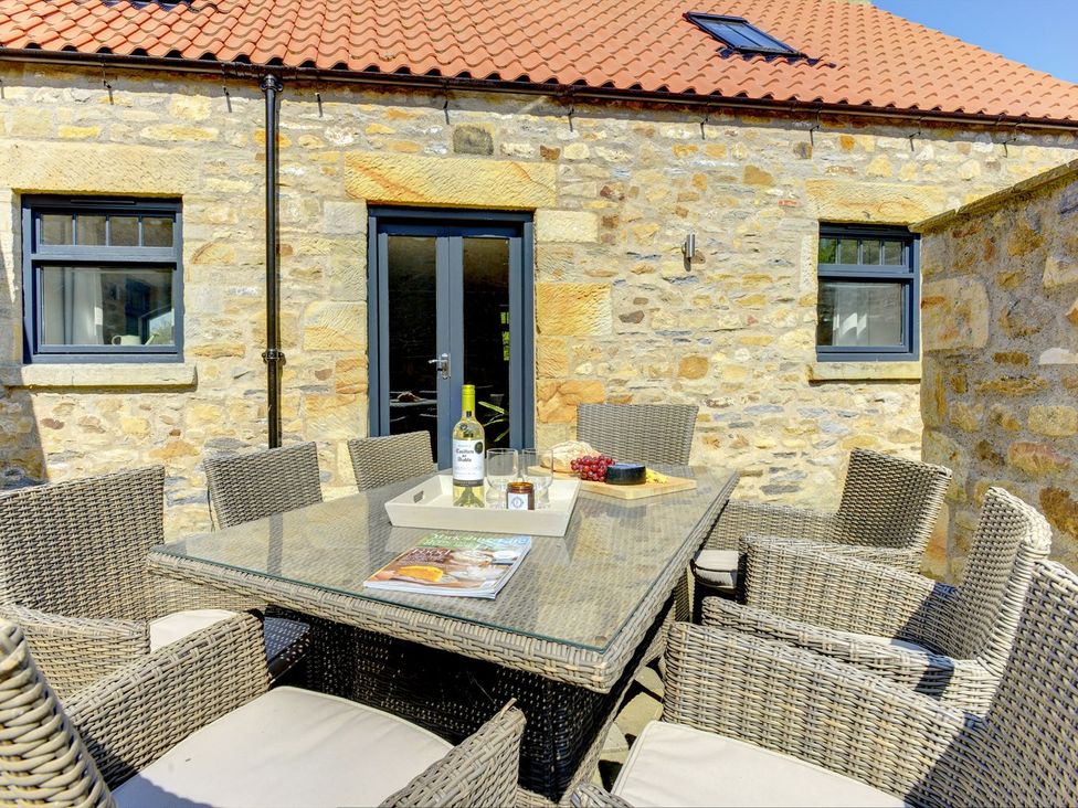An outdoor dining area with a table and chairs at The Gate House in Aldbrough St. John near Barton