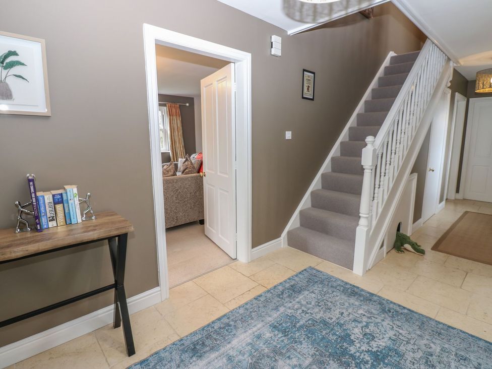 A hallway with a staircase and a table at Hollymoor Hall Farm in Richmond