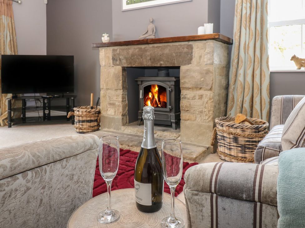 A living room with a fireplace and champagne at Hollymoor Hall Farm in Richmond