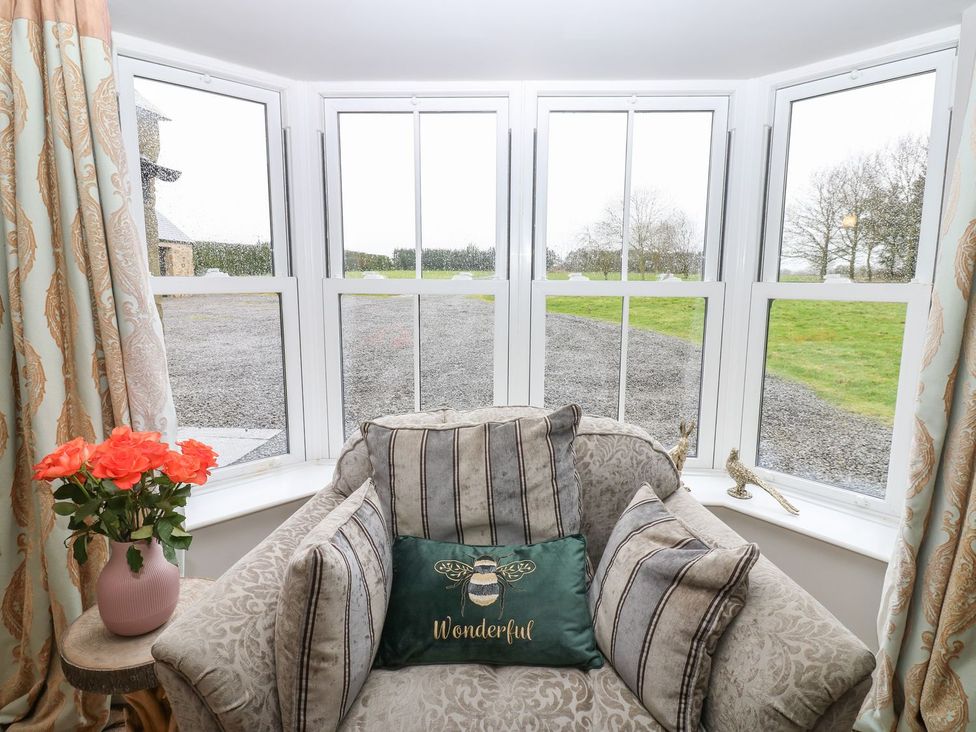 A living room with a chair and windows at Hollymoor Hall Farm in Richmond