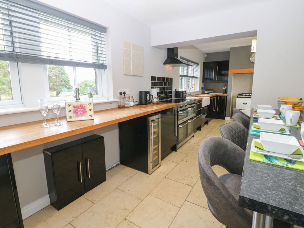 A kitchen with a counter and bar stools at Hollymoor Hall Farm in Richmond