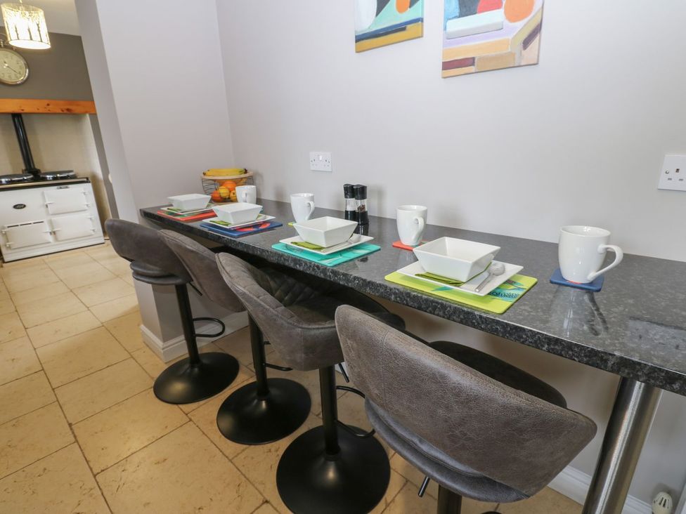 A kitchen with bar stools and countertop setup at Hollymoor Hall Farm in Richmond