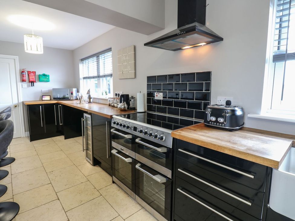 A kitchen featuring black cabinets and appliances at Hollymoor Hall Farm in Richmond