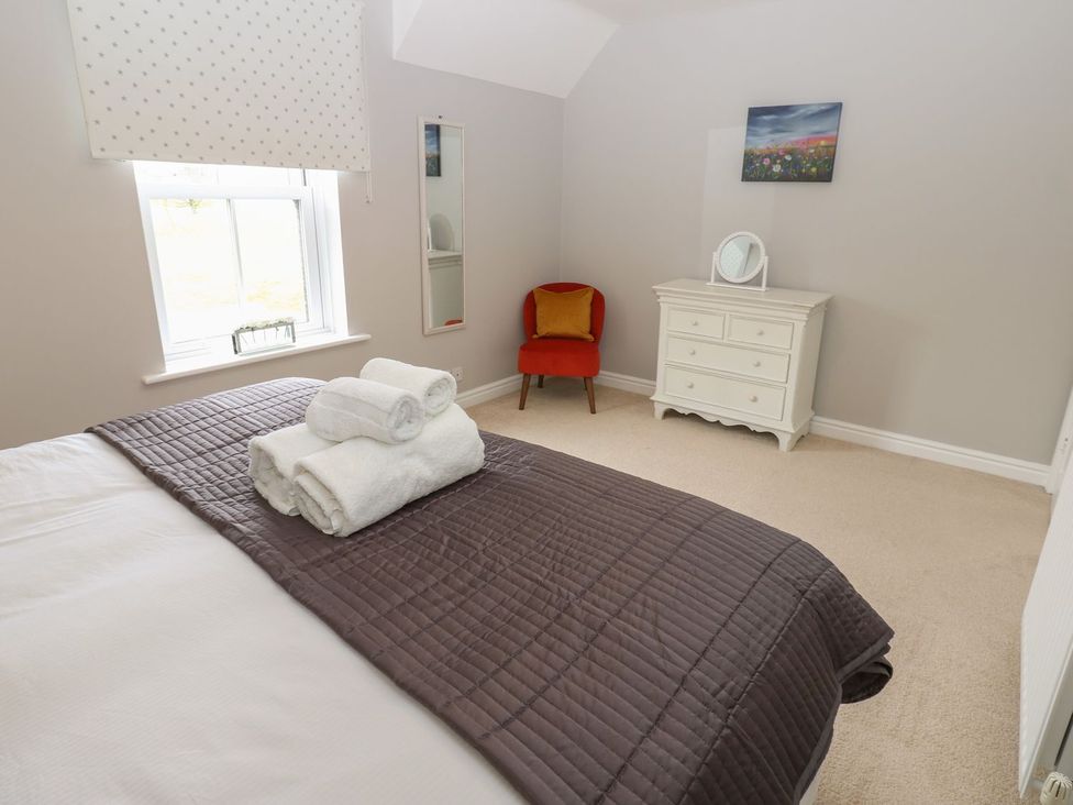 A bedroom with a bed and a chair at Hollymoor Hall Farm in Richmond