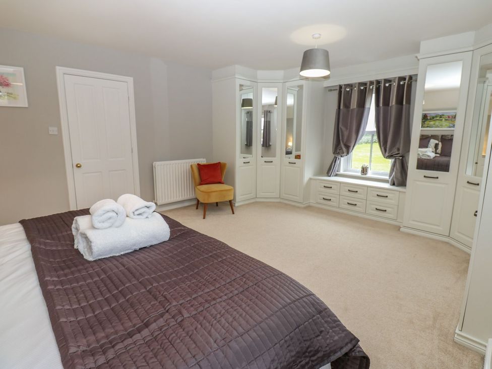 A bedroom with a bed, towels, and wardrobe at Hollymoor Hall Farm in Richmond