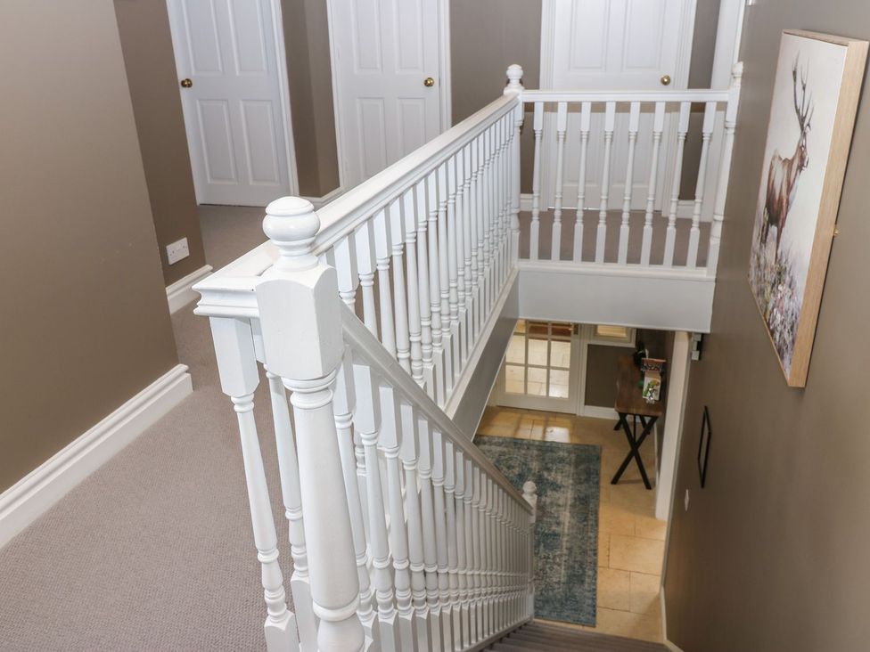 A staircase with railing and doors in a hallway at Hollymoor Hall Farm in Richmond