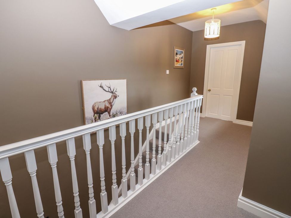A hallway with a railing and paintings at Hollymoor Hall Farm in Richmond
