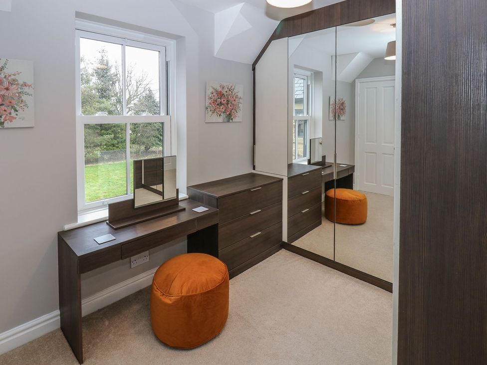 A bedroom with a dressing table and mirror at Hollymoor Hall Farm in Richmond