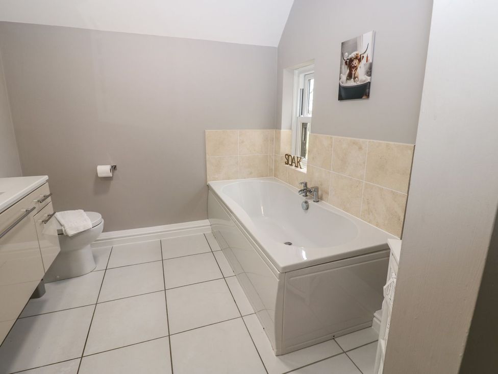 A bathroom featuring a bathtub, toilet, sink, and towel at Hollymoor Hall Farm, Richmond
