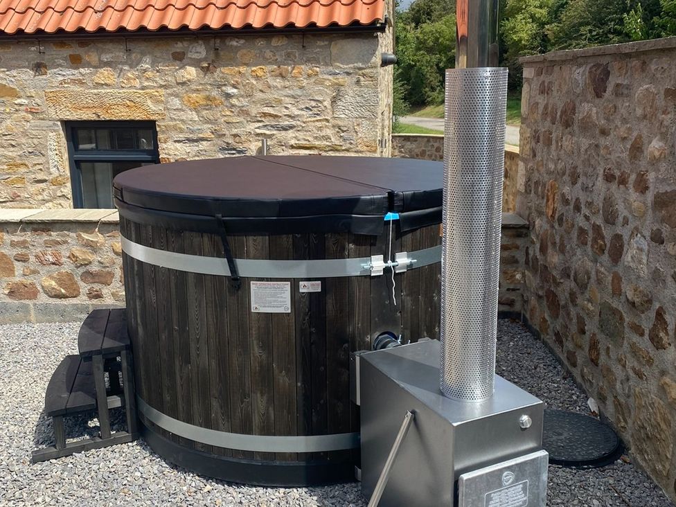 A hot tub with a heating stove outside at Hollymoor Hall Farm in Richmond
