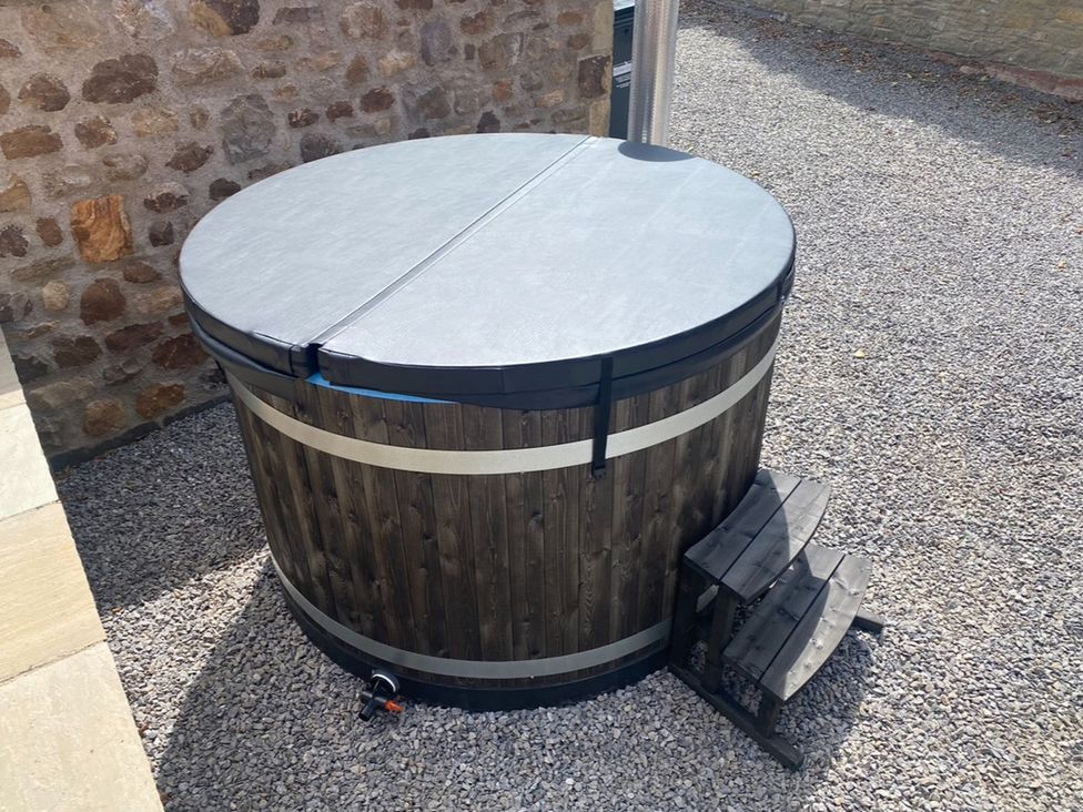 A hot tub with cover and surrounding gravel at Hollymoor Hall Farm Richmond