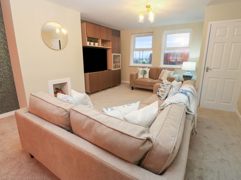 A living room with a sofa and television stand at 11 North Terrace Seaham