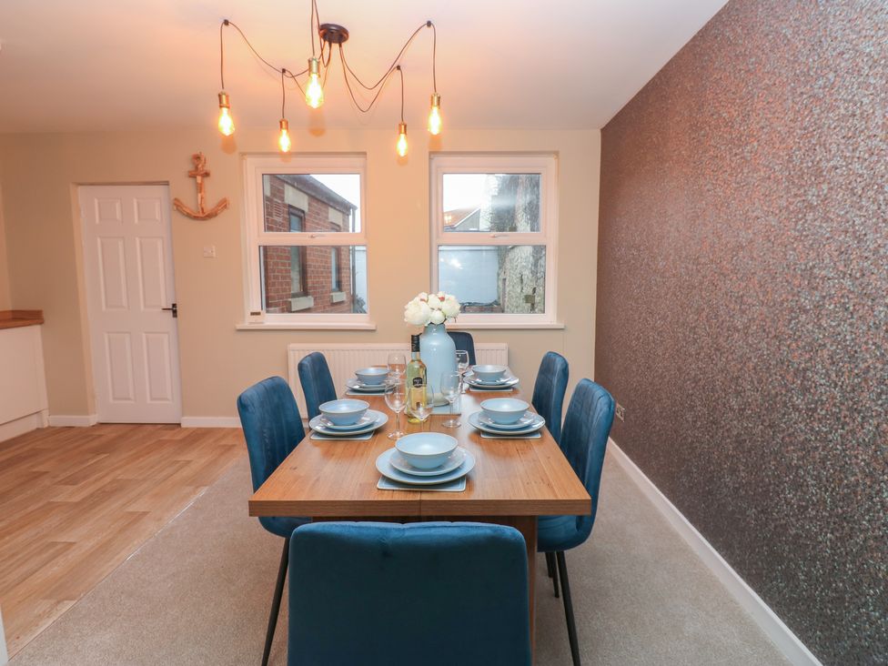 A dining room with a table and chairs at 11 North Terrace in Seaham