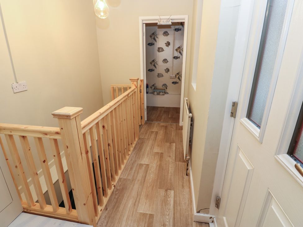 A hallway with a staircase and light fixture at 11 North Terrace in Seaham