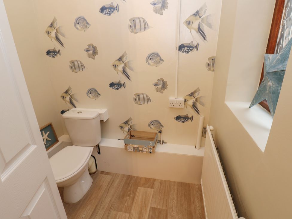 A bathroom with a toilet and fish-themed wallpaper at 11 North Terrace in Seaham