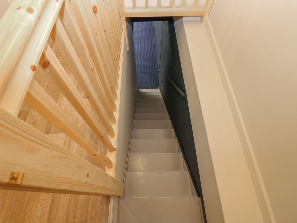 A staircase with wooden railing and carpet at 11 North Terrace in Seaham