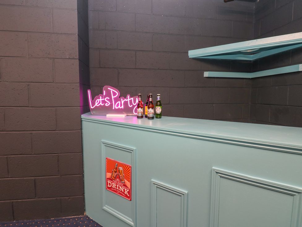 A bar area with drinks and a neon sign at 11 North Terrace in Seaham