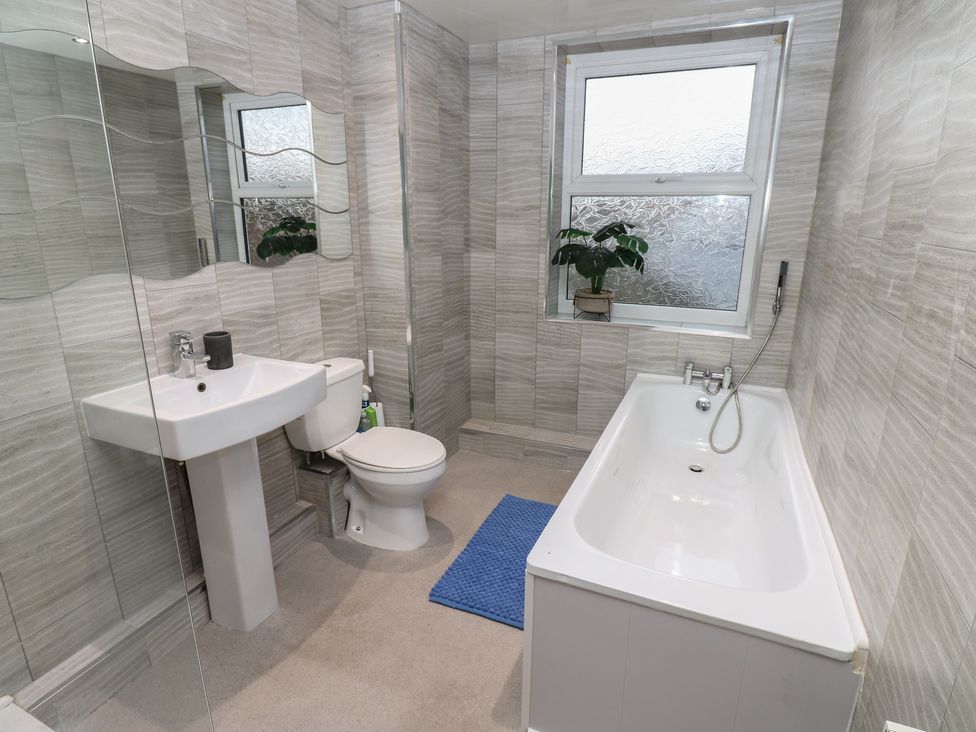 A bathroom with a toilet, sink, bathtub and window at 11 North Terrace, Seaham