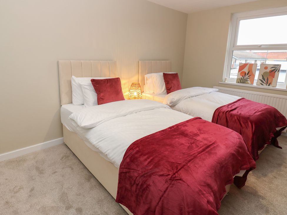 A bedroom with twin beds and decorative wall art at 11 North Terrace in Seaham