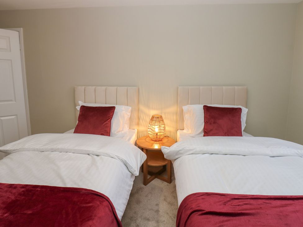 A bedroom with two beds and a lamp at 11 North Terrace Seaham
