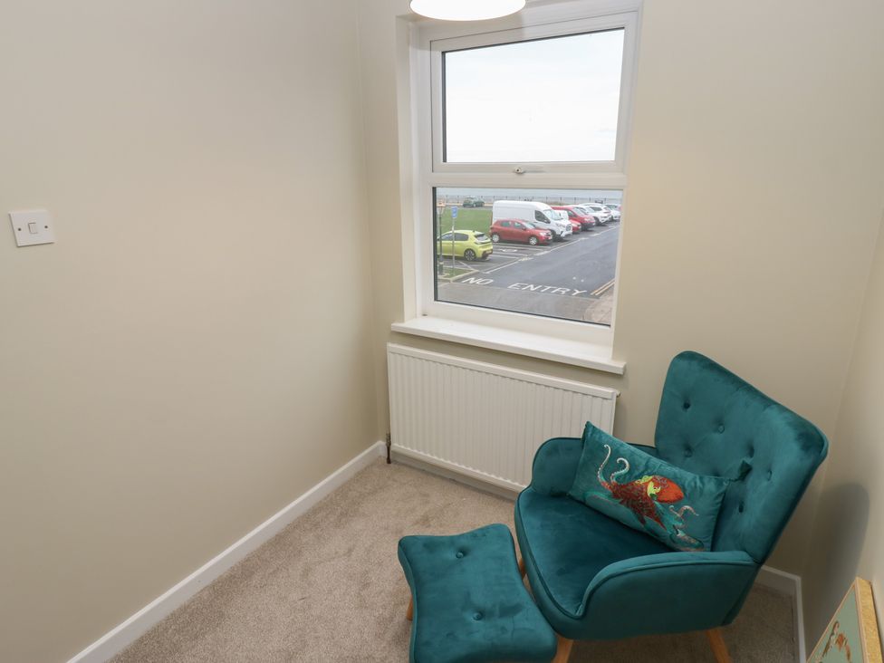 A small room with a chair and ottoman at 11 North Terrace in Seaham