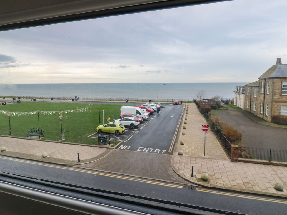 A view of the ocean with cars parked near grass at 11 North Terrace in Seaham