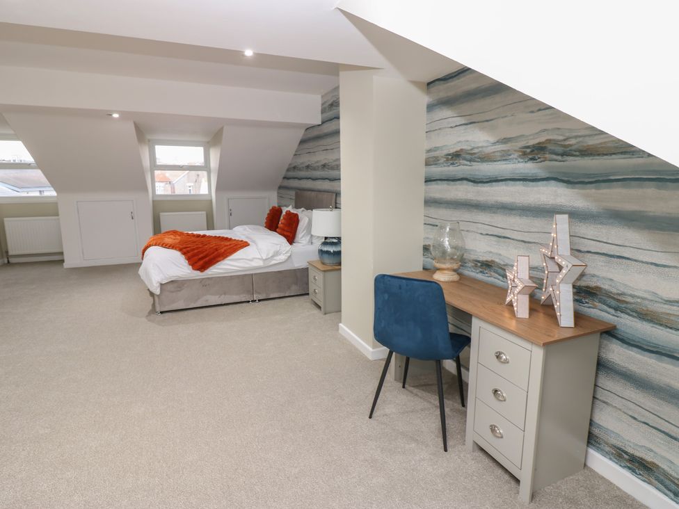 A bedroom with a bed and workspace at 11 North Terrace in Seaham