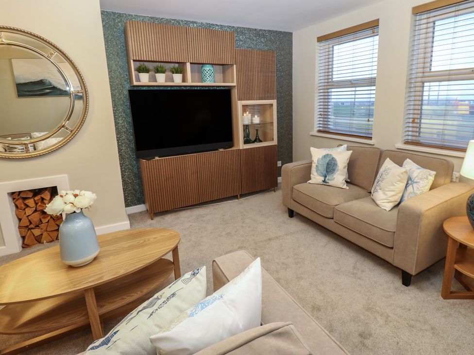 A living room with a television and sofa at Eleven Tides in Seaham