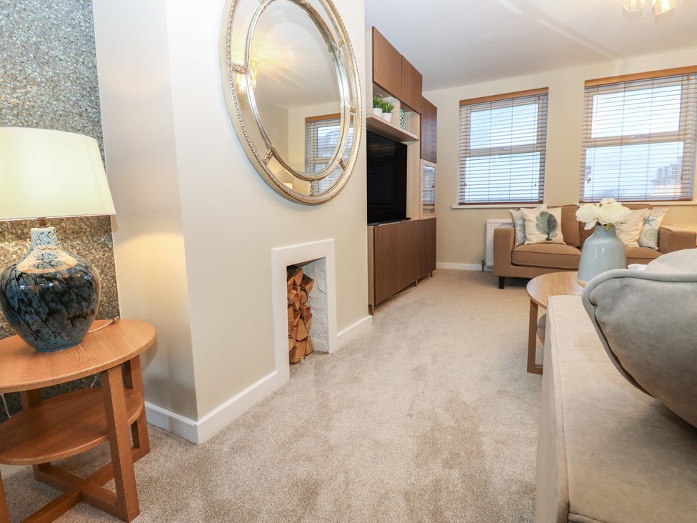 A living room with a television unit and a sofa at Eleven Tides in Seaham