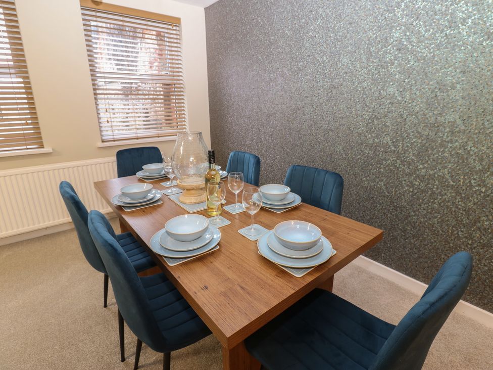 A dining room with a wooden table and chairs at Eleven Tides in Seaham